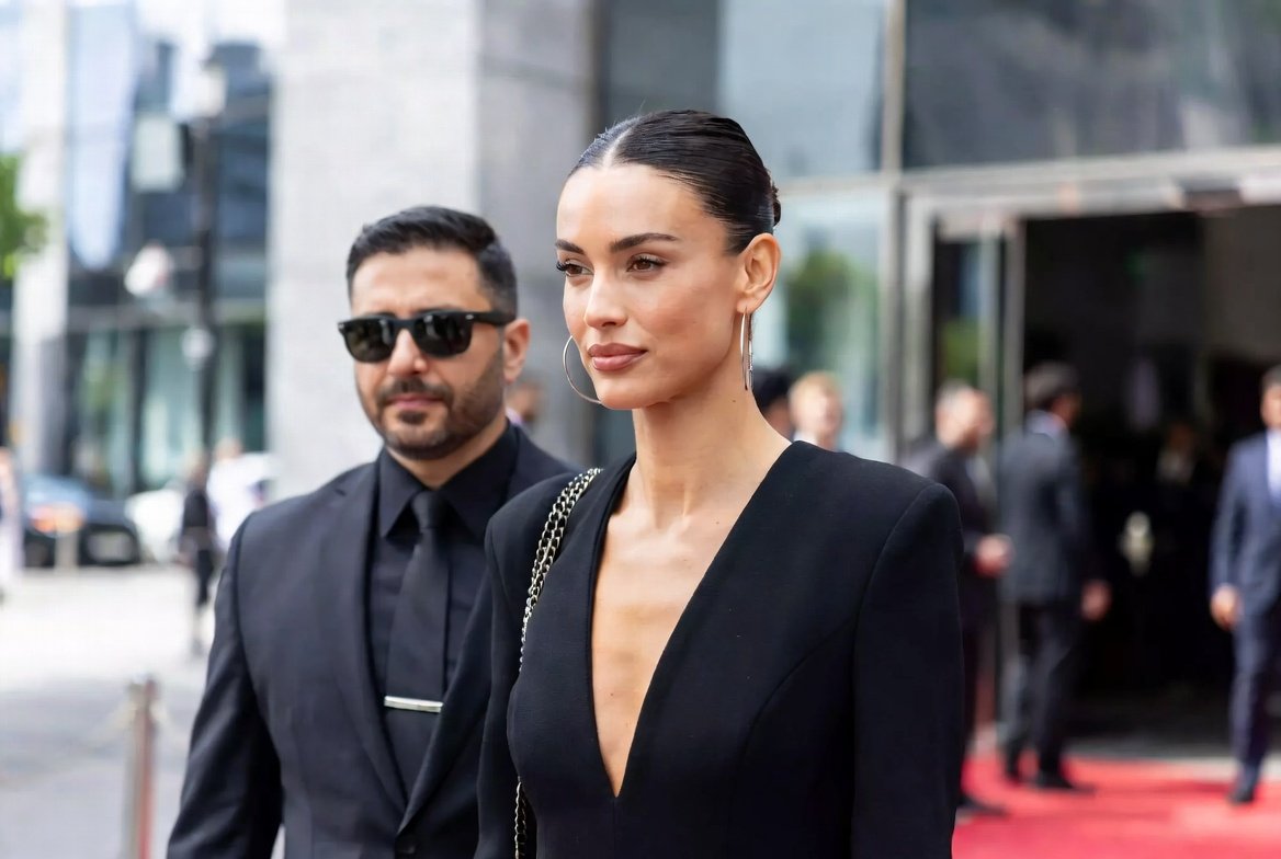 A close protection officer escorts a principal past a red-carpet arrival, the moment paparazzi photographs are built from