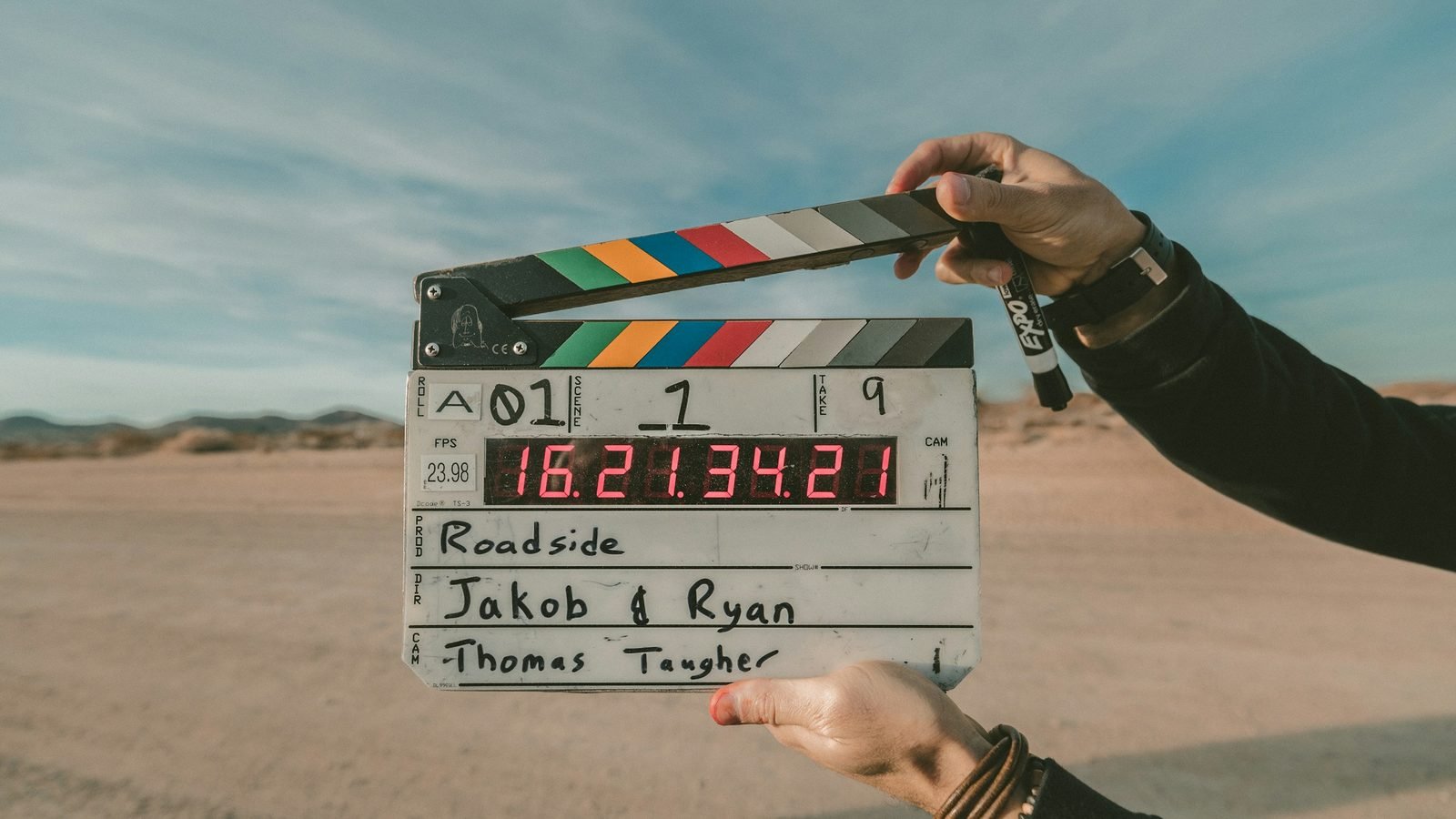 A film clapperboard held up on location on a desert road