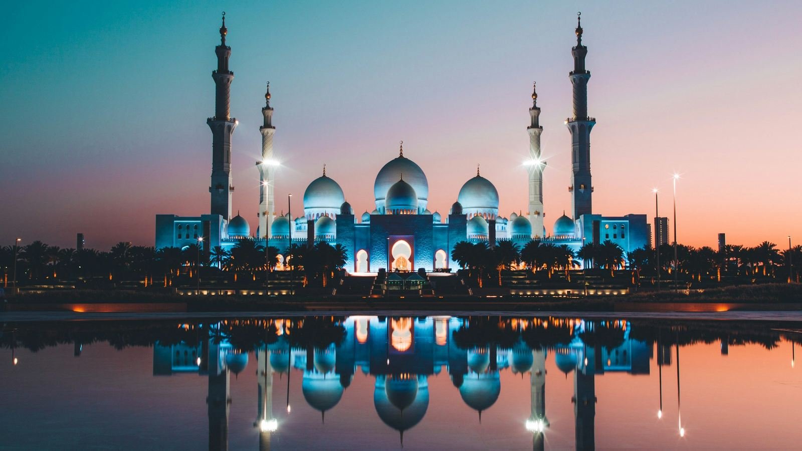Sheikh Zayed Grand Mosque in Abu Dhabi at dusk, reflected in water