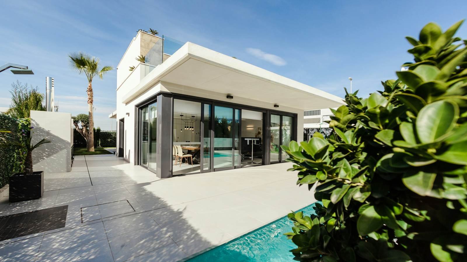 A modern private villa with a pool and terrace under clear skies