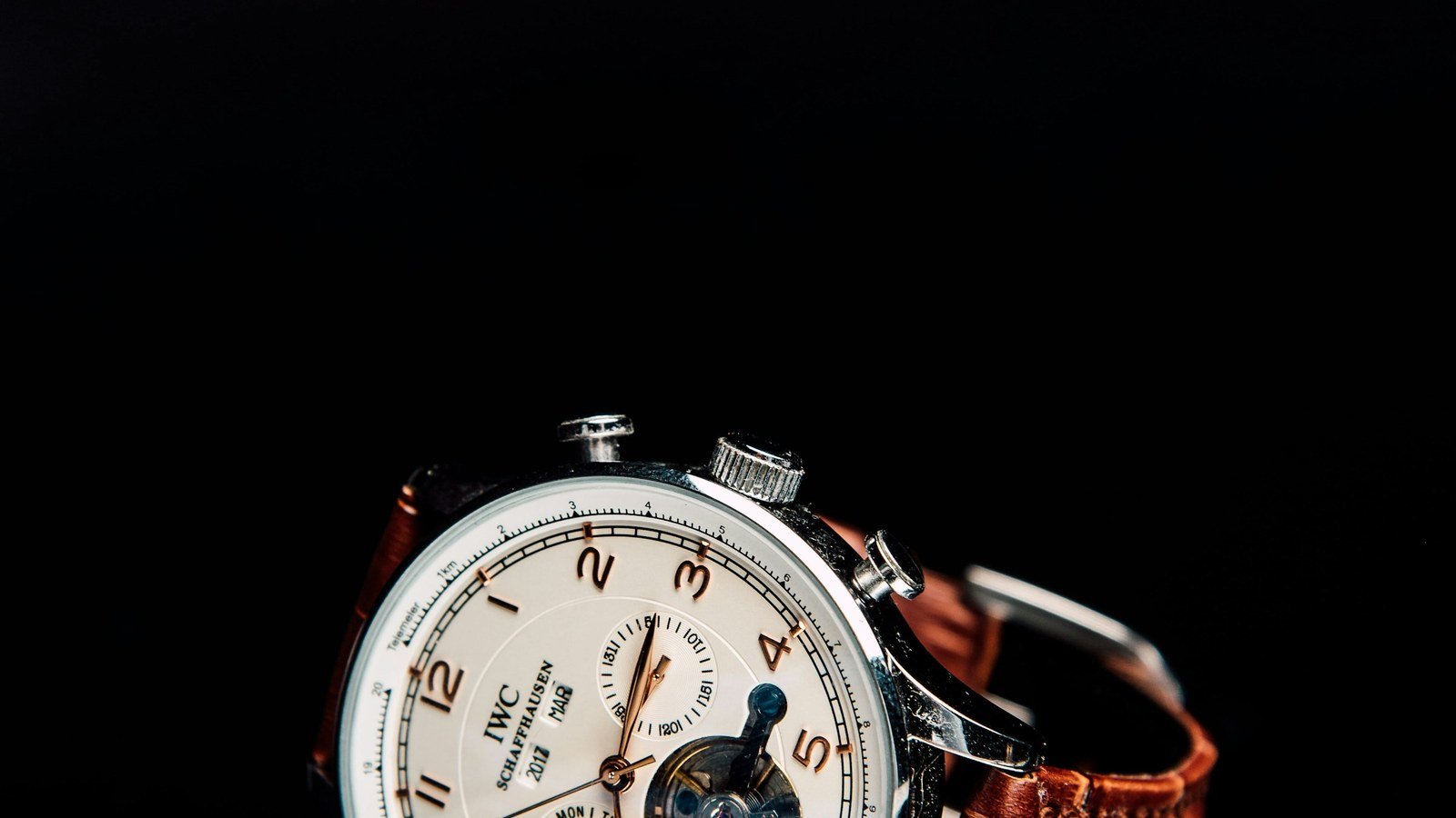 An elegant chronograph wristwatch resting on a dark background