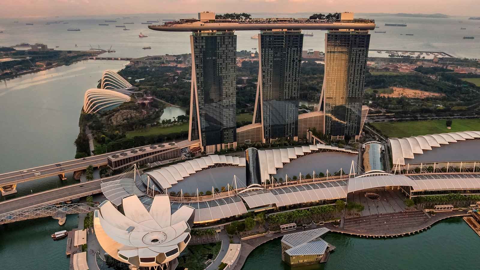Aerial view of Marina Bay, Singapore, at dusk with the waterfront skyline and harbour beyond